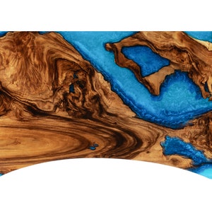 May include: A large wooden serving board with a blue epoxy resin inlay. The wood has a dark brown color and a natural grain pattern. The resin is a bright blue color and has a smooth, glossy finish.