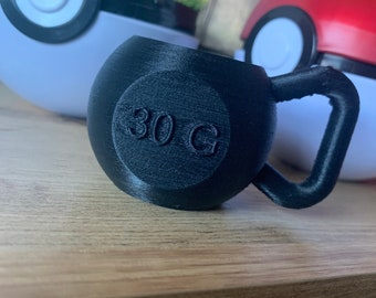Può includere: Un kettlebell nero da 30 g con manico. Il kettlebell è realizzato in materiale testurizzato e ha un manico liscio.