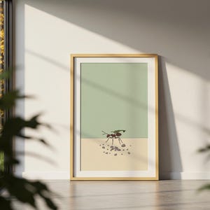 May include: A framed art print featuring a minimalist illustration of an ant carrying small stones. The artwork has a two-tone background with a light green upper section and a beige lower section. The frame is a light wood color.