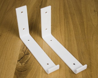 May include: Two white metal shelf brackets with four holes each. The brackets are L-shaped and have a slight curve at the bottom.