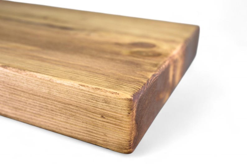Peut inclure: Gros plan sur une &eacute;tag&egrave;re rectangulaire en bois avec une finition marron chaud et naturelle. Le grain du bois est visible et les bords ont une apparence l&eacute;g&egrave;rement plus fonc&eacute;e et br&ucirc;l&eacute;e. L'&eacute;tag&egrave;re est probablement pour la d&eacute;coration int&eacute;rieure.