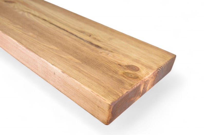 Peut inclure: Gros plan sur une &eacute;tag&egrave;re rectangulaire en bois brun clair. Le grain du bois est visible, avec des n&oelig;uds et des variations naturelles de couleur. Les bords sont carr&eacute;s et l'&eacute;tag&egrave;re semble inachev&eacute;e ou l&eacute;g&egrave;rement teint&eacute;e. L'&eacute;tag&egrave;re est inclin&eacute;e, sur fond blanc.