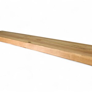 Peut inclure: Une &eacute;tag&egrave;re rectangulaire en bois non fini, d'environ 122 cm de long, avec un grain de bois naturel. L'&eacute;tag&egrave;re est brun clair et semble &ecirc;tre faite d'une seule pi&egrave;ce de bois. Les bords sont grossi&egrave;rement coup&eacute;s, ce qui lui donne un aspect rustique.