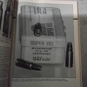 May include: An image of a box of "SUPER VEL" 357 AMP cartridges. The box is light gray with black text. Several cartridges are displayed next to the box. The text on the box reads "50 CENTER FIRE 137 gr. JSP CARTRIDGES".