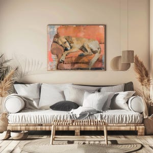 May include: A painting of a dog sleeping on a pink couch. The painting is framed and hanging on a wall in a living room with a couch and pillows.