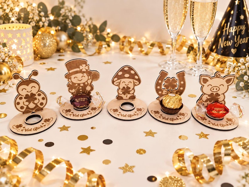 May include: Five light-colored wooden stands featuring laser-cut designs of a ladybug, a person in a top hat, a mushroom, a horseshoe, and a pig. Each stand has a circular cutout for a candy and the German text Viel Gl&uuml;ck engraved on the base.