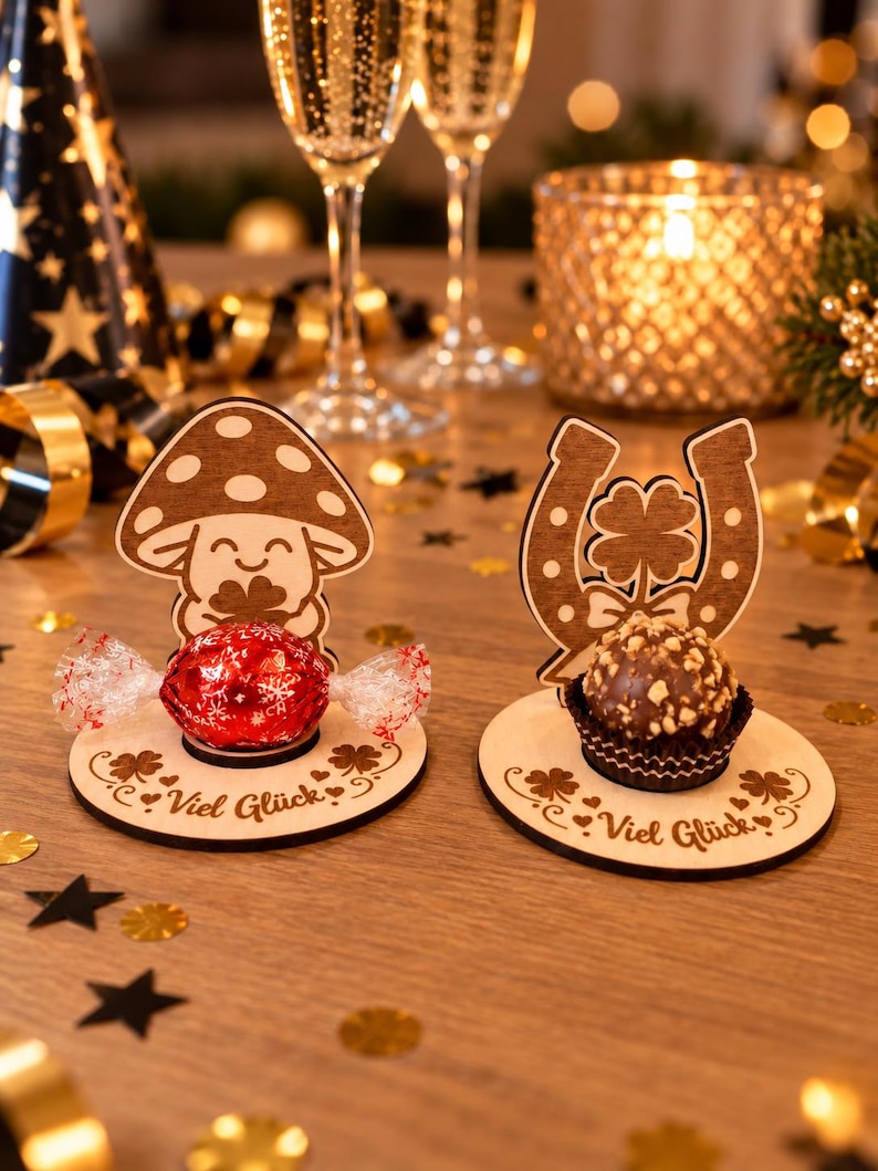 May include: Two circular wooden stands featuring laser-cut designs. One stand displays a smiling mushroom holding a clover, while the other shows a horseshoe with a four-leaf clover. Both bases are engraved with the German text Viel Gl&uuml;ck.
