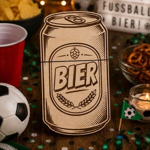 Könnte beinhalten: Ein helles Holzausschnitt in Form einer Getränkedose mit lasergraviertem Design. In der Mitte steht das Wort BIER in fetten Buchstaben, gekrönt von einem Hopfensymbol und umrahmt von Weizenähren, was eine klassische Bieretikettenoptik imitiert.