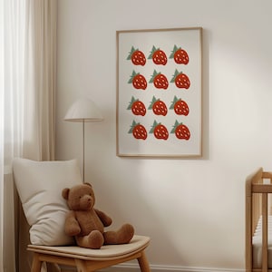 May include: A framed print with a white background and a repeating pattern of red strawberries with green leaves.