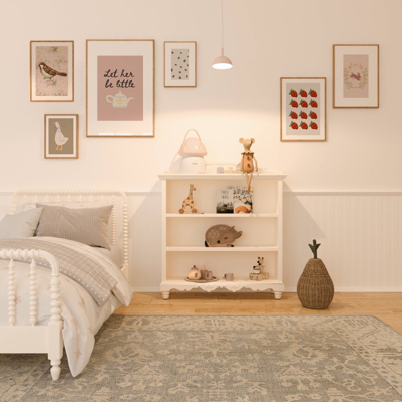 May include: A white wooden bookshelf with a white background. The bookshelf has three shelves and is filled with various items, including a stuffed animal, a book, a toy giraffe, and a tea set. There is a white rug on the floor in front of the bookshelf.