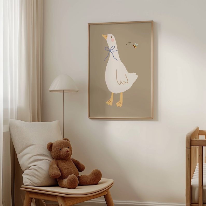 May include: A framed illustration of a white goose with a blue bow, looking to the right, with a small bee flying above it. The background is a light brown color.