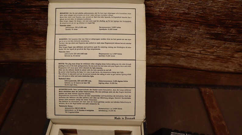 May include: Close-up of a white box with black text containing instructions and warnings for a product. The text is in Danish and includes the words "Bem&aelig;rk", "Note", and "Anmerkung". The box also has the words "Made in Denmark" printed on the bottom.