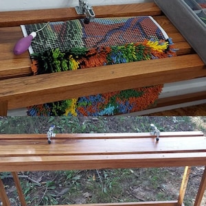 May include: A wooden frame with two metal clamps on the top and bottom. The frame is used to hold a rug or tapestry in place while it is being worked on. The rug is colorful and has a variety of textures.