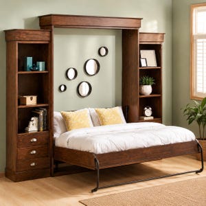 May include: A dark wood Murphy bed with built-in bookshelves on either side. The bed is made up with white bedding and yellow patterned pillows. The wall behind the bed has several round mirrors. A small clock and potted plant sit on the shelves.