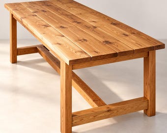 May include: A rectangular dining table constructed from light brown wood with a visible grain and natural knots. The tabletop consists of four parallel planks supported by four sturdy legs connected by a horizontal crossbar frame.