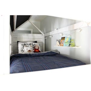 May include: A white wooden house-shaped bed frame with a blue plaid blanket. A pillow with the word "young" and a teddy bear and monkey plush toys are on the bed. A shelf holds books and stuffed animals.