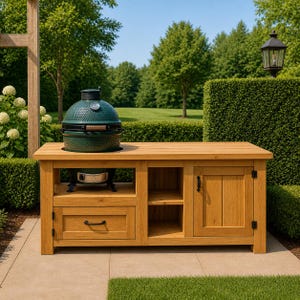 May include: A wooden outdoor kitchen island with a dark green ceramic grill on top. The island has a drawer, cabinet, and open shelving. The island is made of light-colored wood and is set on a patio with a green lawn and trees in the background.