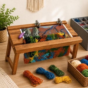May include: A wooden rug hooking frame with a colorful, textured rug in progress. The frame is brown and has metal clasps. Bundles of yarn in various colors, including orange, blue, green, and yellow, are scattered around the frame, suggesting a craft project.