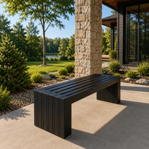 May include: A black outdoor bench with a slatted seat and solid legs. The bench is made of wood and is approximately 60 inches long. It is placed on a concrete patio with a natural outdoor background.