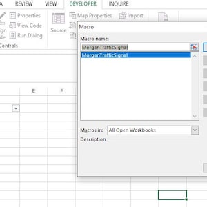 Puede incluir: Una captura de pantalla de una hoja de cálculo de Microsoft Excel con una ventana emergente titulada "Macro". La ventana tiene un campo de texto etiquetado como "Nombre de la macro:" con el texto "MorganTrafficSignal" ingresado. La ventana también tiene un menú desplegable etiquetado como "Macros en:" con el texto "Todos los libros de trabajo abiertos" seleccionado.