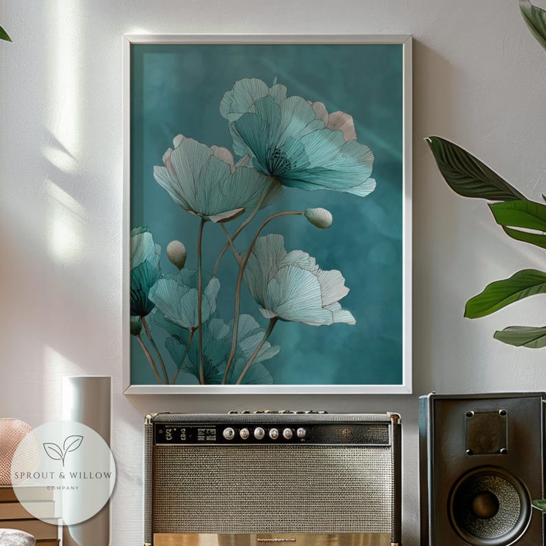 A teal botanical digital art print featuring delicate line-drawn flowers with soft, textured petals set against a smooth teal background. The artwork is displayed in a gold frame on a white paneled wall, creating a modern, elegant, nature-inspired aesthetic. Perfect for living room, bedroom, or entryway decor. Digital download floral wall art with soft teal tones and minimalistic botanical style.