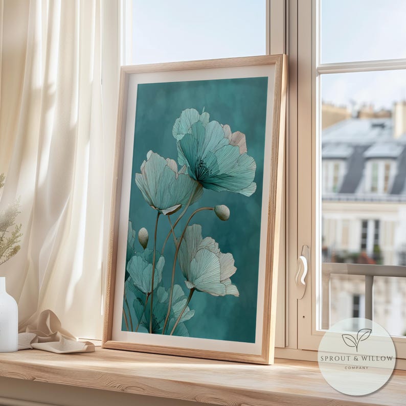 A teal botanical digital art print featuring delicate line-drawn flowers with soft, textured petals set against a smooth teal background. The artwork is displayed in a gold frame on a white paneled wall, creating a modern, elegant, nature-inspired aesthetic. Perfect for living room, bedroom, or entryway decor. Digital download floral wall art with soft teal tones and minimalistic botanical style.
