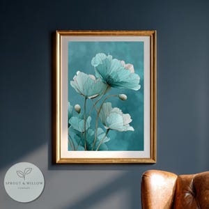 A teal botanical digital art print featuring delicate line-drawn flowers with soft, textured petals set against a smooth teal background. The artwork is displayed in a gold frame on a white paneled wall, creating a modern, elegant, nature-inspired aesthetic. Perfect for living room, bedroom, or entryway decor. Digital download floral wall art with soft teal tones and minimalistic botanical style.