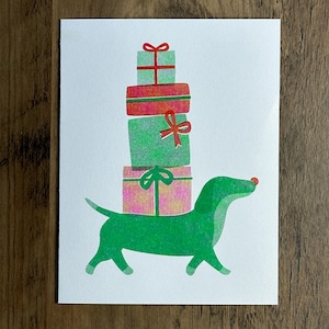 Carte de vœux pour les Fêtes Teckel Rudolph portant des cadeaux
