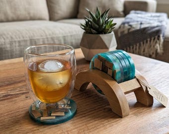 Four 3"(4) handmade wood and resin coasters and one (1) custom matching wooden display stand.