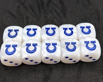 Puede incluir: Diez dados blancos con símbolos omega azules en cada cara. Los dados están dispuestos en una fila.