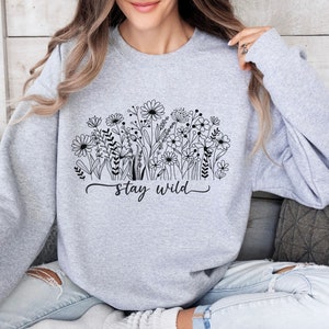 May include: A gray sweatshirt with a black floral design and the text "stay wild".