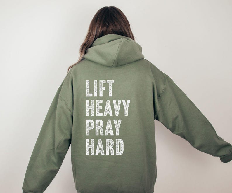 May include: A green hooded sweatshirt with the text "LIFT HEAVY PRAY HARD" printed in white on the back.