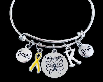 May include: Silver-toned charm bracelet with multiple dangles. Charms include the words "Faith" and "Hope", a yellow ribbon, a letter "K", and a circular charm with the word "Survivor" and a butterfly design.