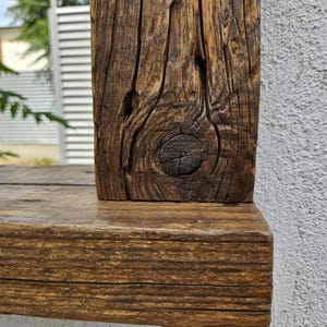 May include: Close-up of a rustic wooden frame with a knot in the wood. The frame is stained a dark brown color.