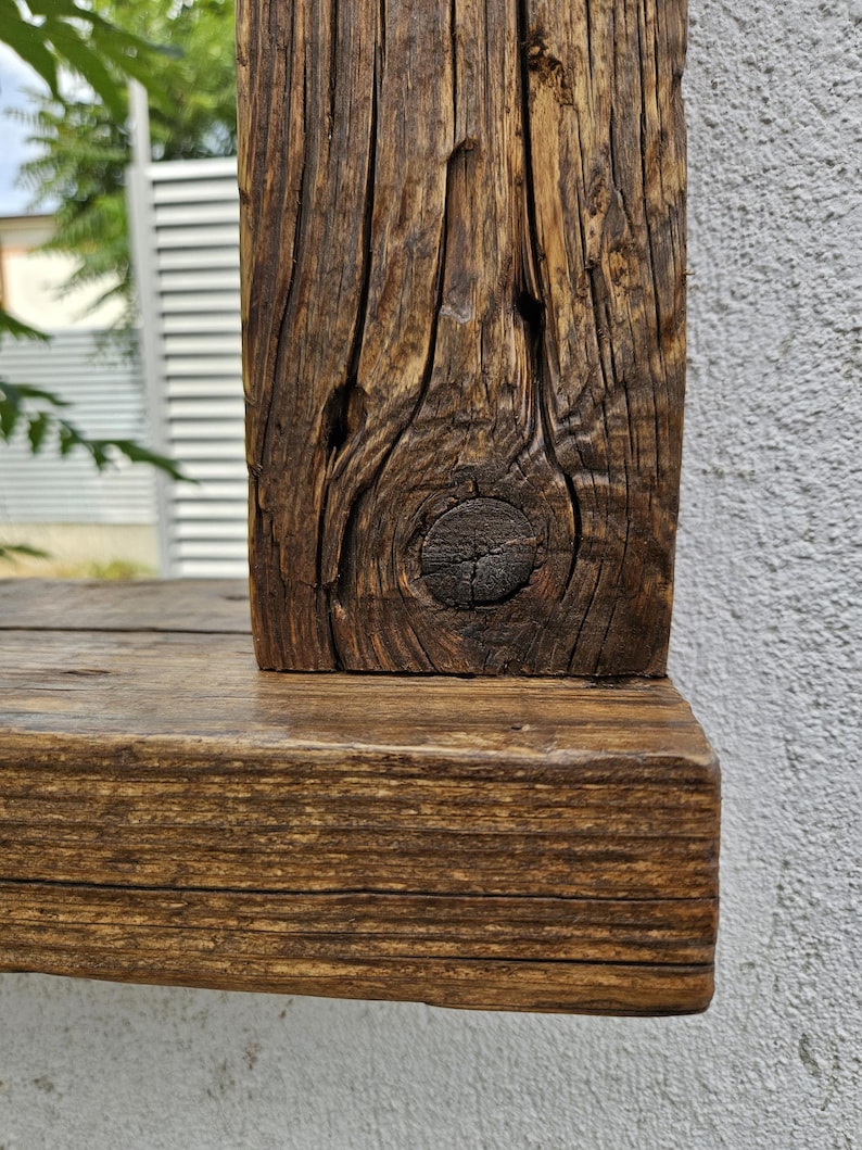 May include: Close-up of a rustic wooden frame with a knot in the wood. The frame is stained a dark brown color.