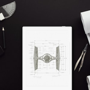 Puede incluir: Plano detallado de un caza TIE, mostrado sobre papel cuadriculado, con medidas. La imagen está sobre una superficie negra, junto a un portátil, un lápiz, un transportador y planos arquitectónicos enrollados. También hay un compás.