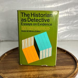May include: A hardcover book titled The Historian as Detective Essays on Evidence edited by Robin W. Winks. The cover is olive green with black text and a graphic illustration featuring orange and light blue rectangular blocks.