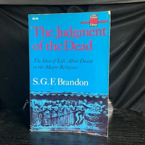 May include: A vintage book titled "The Judgment of the Dead" with a bright blue cover. The title is in large red letters, with the author's name, S.G.F. Brandon, in white. The book's cover also features an illustration of figures in a classical style.