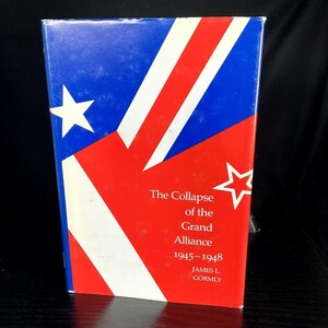 May include: A hardcover book titled "The Collapse of the Grand Alliance 1945-1948" by James L. Gormly. The cover features a design with blue, red, and white stripes and stars, resembling a flag.