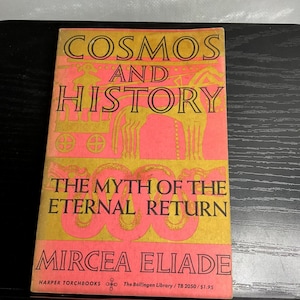 May include: A paperback book titled Cosmos and History: The Myth of the Eternal Return by Mircea Eliade. The cover features a pink and gold color scheme with black text and a stylized illustration of a horse-drawn chariot and serpent motifs.