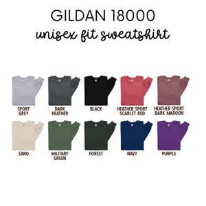 May include: A Gildan 18000 unisex fit sweatshirt is shown in 12 different colors: Sport Grey, Dark Heather, Black, Heather Sport Scarlet Red, Heather Sport Dark Maroon, Sand, Military Green, Forest, Navy, and Purple.