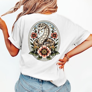 May include: White t-shirt with a vintage-style illustration of a snake with flowers on the back.