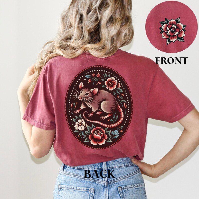 May include: A maroon t-shirt with a floral design featuring a rat on the back. The design is in a circle with a dark background and colorful flowers.