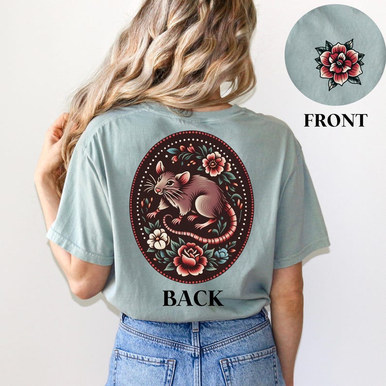 May include: A light blue t-shirt with a floral design featuring a rat and the word "BACK" printed on the back.