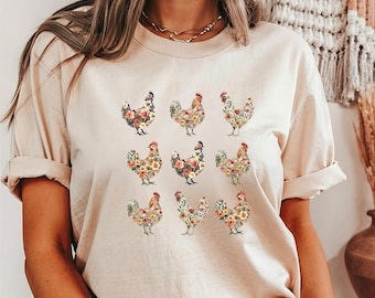 May include: A beige t-shirt with a floral pattern of nine chickens. Each chicken is made up of different colored flowers.
