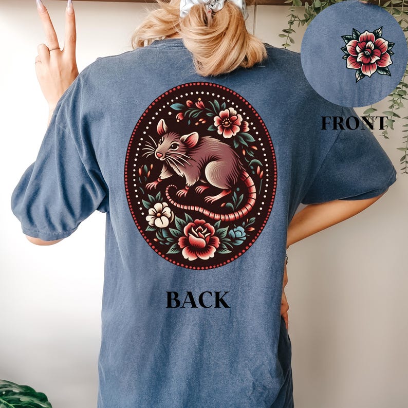 May include: A blue t-shirt with a floral design featuring a rat and the words "BACK" and "FRONT" printed on the back and front of the shirt.