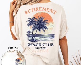 May include: A beige t-shirt with a graphic print of palm trees, a sunset, and the text "Retirement Beach Club Est. 2025 Key West, Florida".