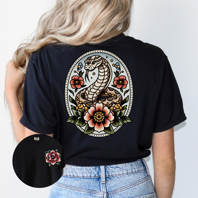 May include: Black t-shirt with a vintage-style tattoo design of a snake with flowers on the back. The design is in an oval frame with a blue background.