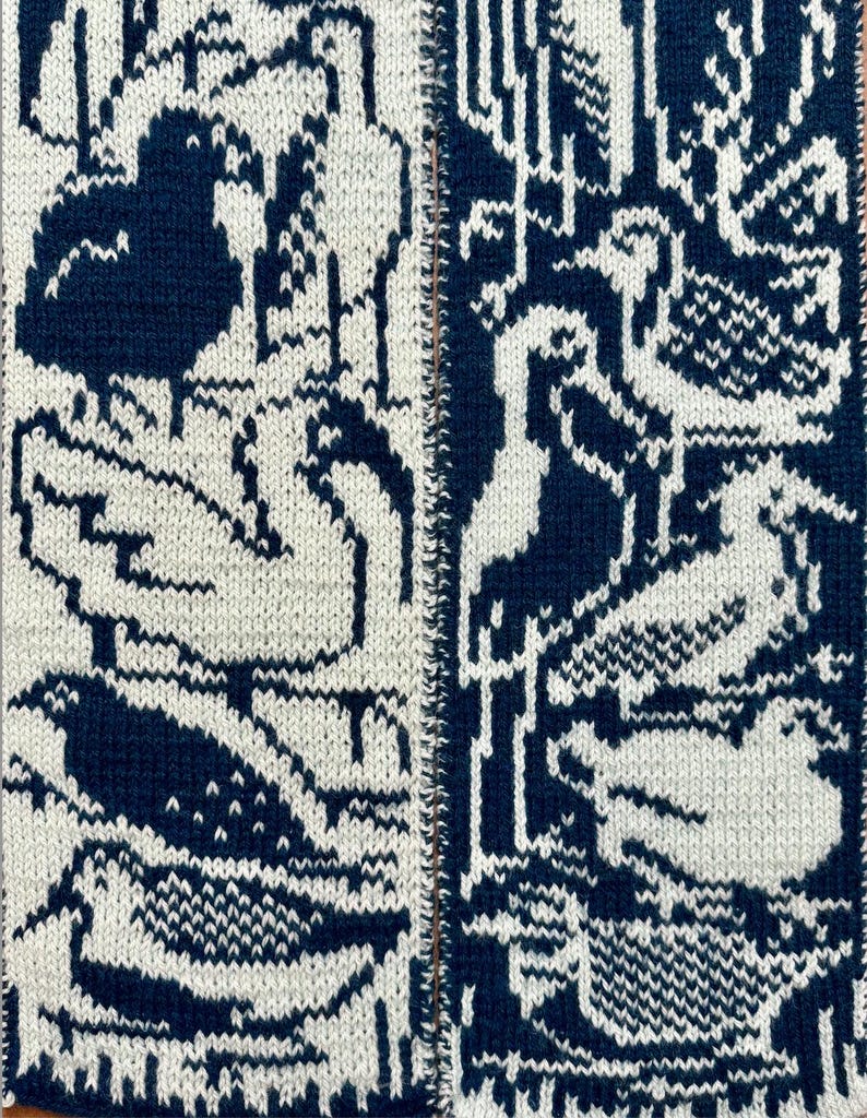 Puede incluir: Primer plano de un textil tejido con un patr&oacute;n repetido de aves en azul marino y blanco. Las aves est&aacute;n estilizadas, con alas y cuerpos detallados. El fondo es de color crema y la textura del tejido es visible.