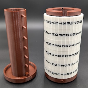 May include: A brown and white cylinder shaped puzzle with a series of letters and numbers printed on the white cylinder. The cylinder is made of plastic and has a brown base. The puzzle is designed to be rotated and manipulated to solve a code.